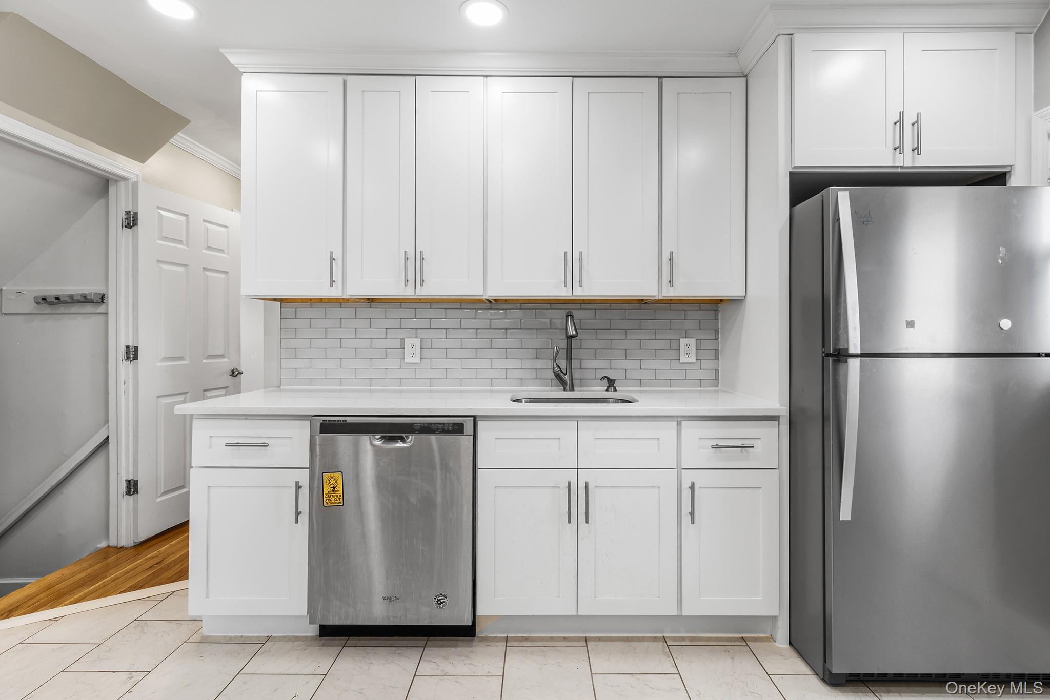 119 Osborne Road West Hempstead, NY 11552 - Photo 12 of 34 a kitchen with stainless steel appliances granite countertop a refrigerator a sink and white cabinets