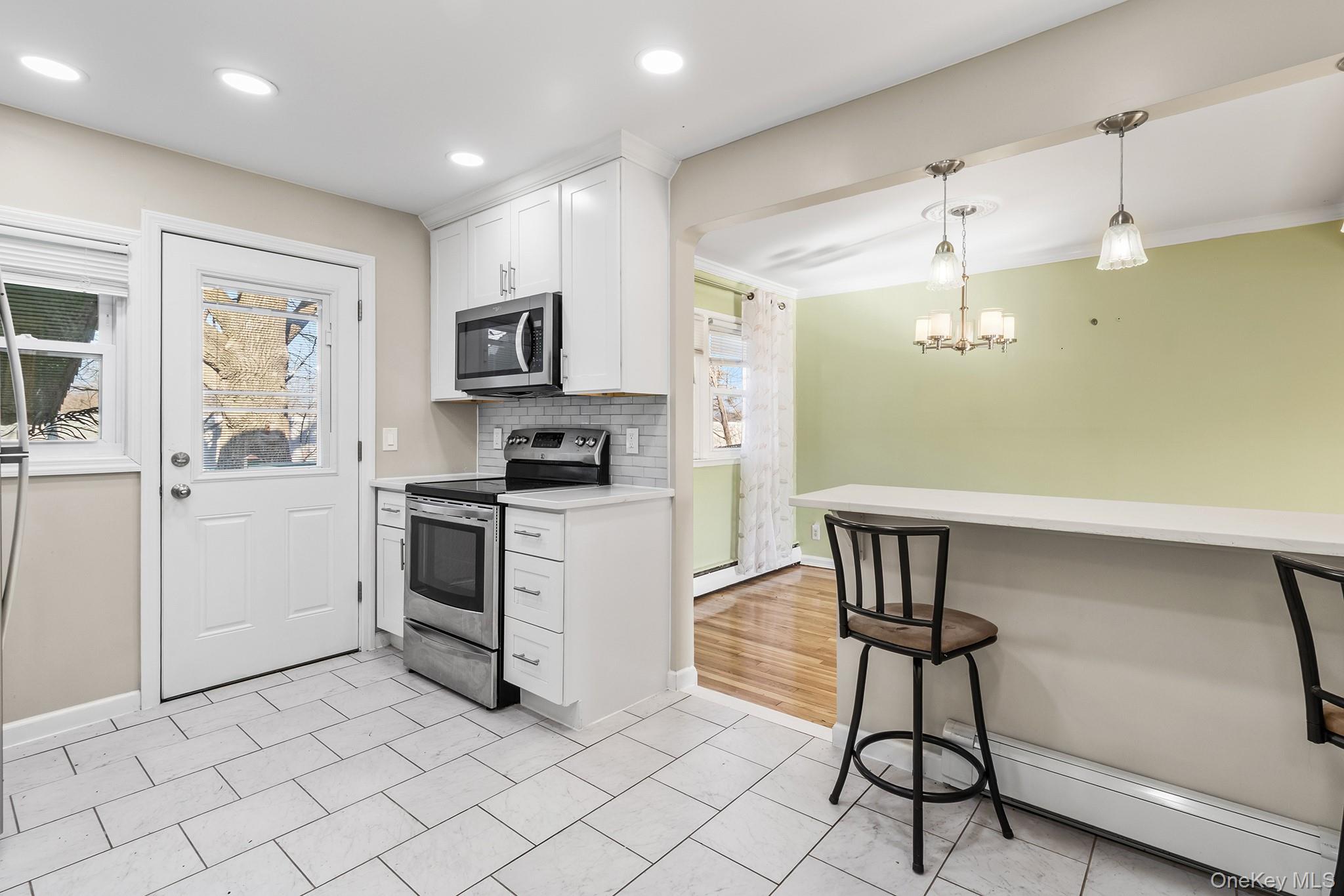 119 Osborne Road West Hempstead, NY 11552 - Photo 13 of 34 a kitchen with white cabinets and appliances