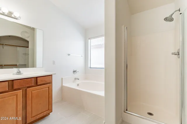 a bathroom with a tub sink and mirror