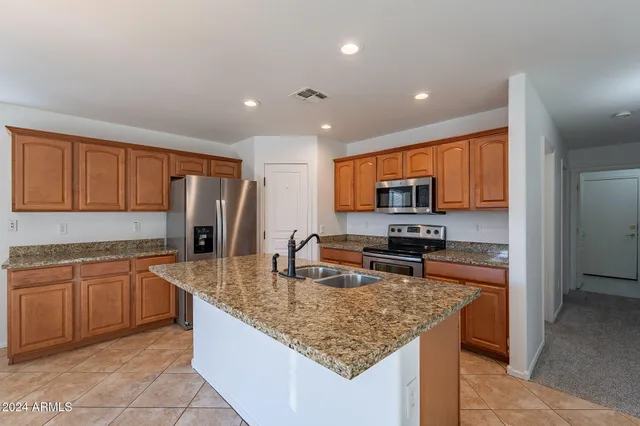 a kitchen with stainless steel appliances granite countertop a sink refrigerator and microwave