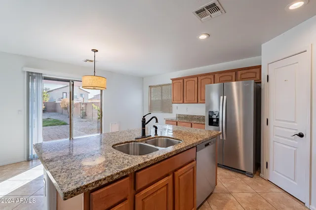 a kitchen with stainless steel appliances granite countertop a sink and a refrigerator