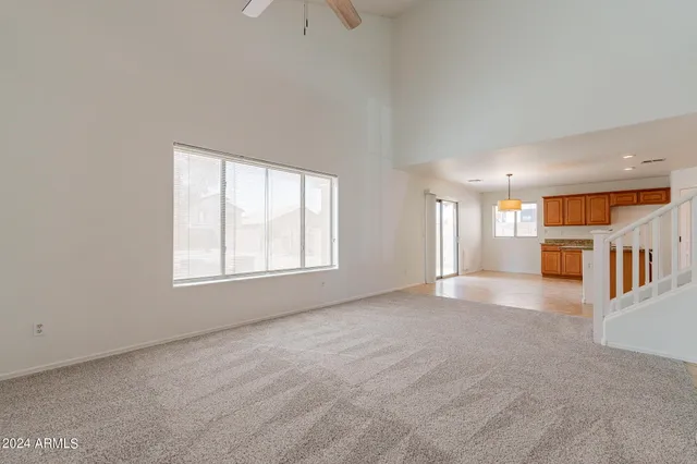 an empty room with a kitchen and a window