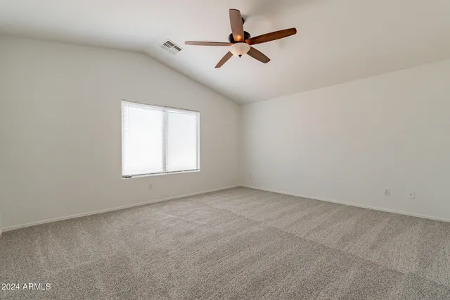 an empty room with a window and a fan