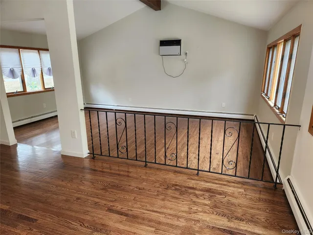 a view of a room with wooden floor and windows