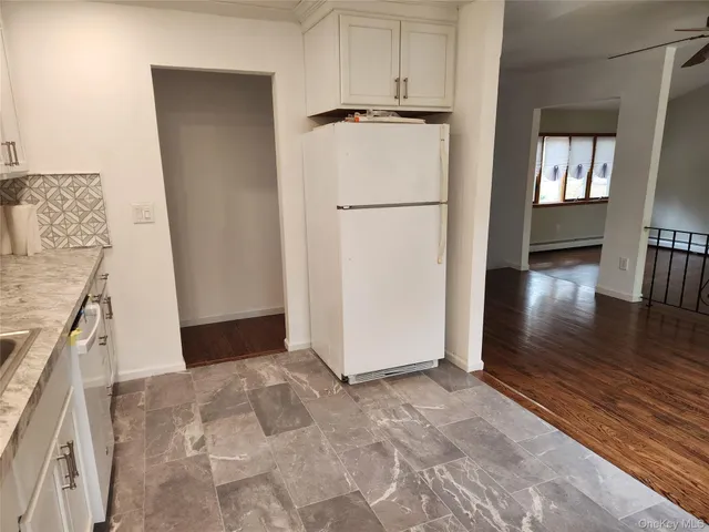 a view of a kitchen with wooden floor and electronic appliances