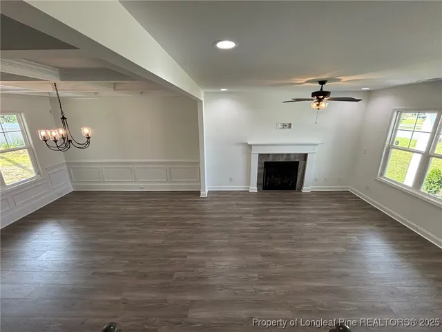an empty room with windows and fireplace