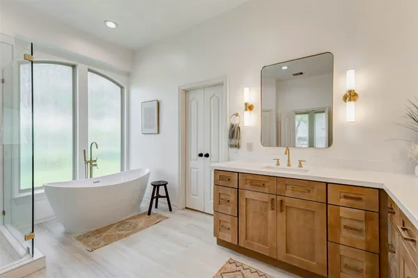 a spacious bathroom with a double vanity sink a mirror and a bathtub