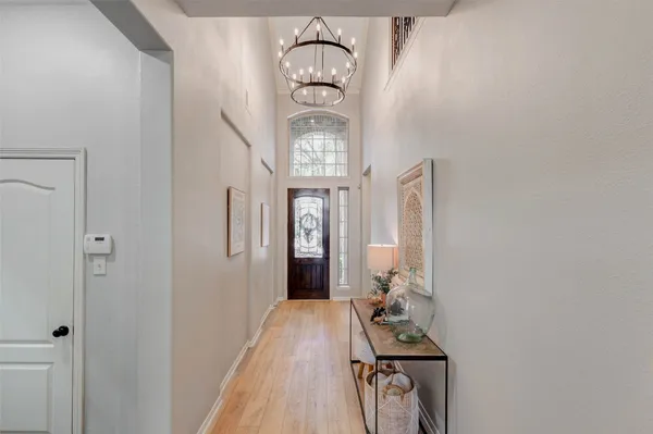 a kitchen with white cabinets and chandelier