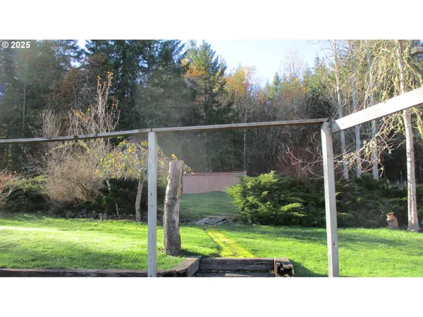 a sign board with flower plants and wooden fence