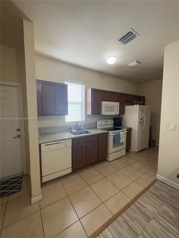 a kitchen with a sink a counter top space and appliances
