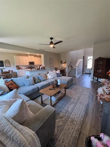 a living room with furniture ceiling fan and a rug