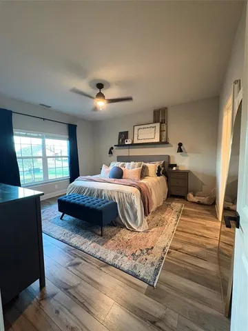 a bedroom with a bed and wooden floor