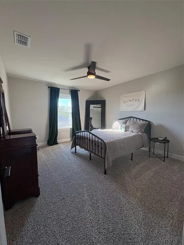 a bedroom with a bed and a ceiling fan