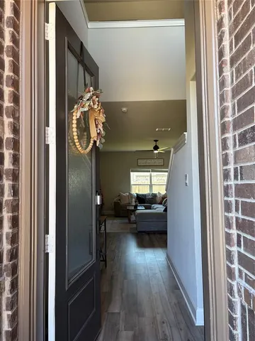 a view of hallway with furniture and wooden floor