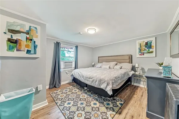 a bedroom with a bed and painting on the wall