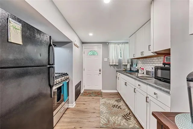 a kitchen with granite countertop a refrigerator and a sink