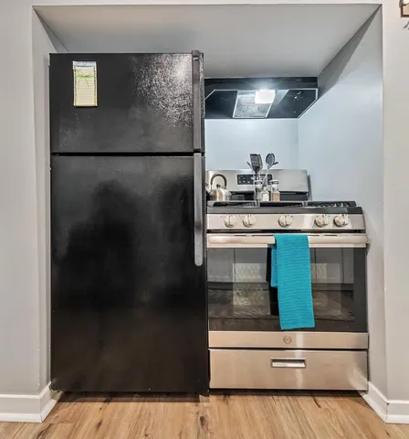 a kitchen with a refrigerator and a stove