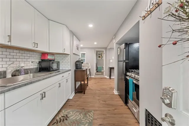 a kitchen with granite countertop a refrigerator and a sink