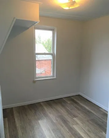 a view of a room that has wooden floor and window