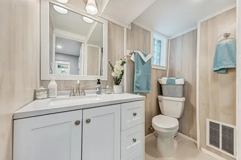 a bathroom with a toilet sink and mirror