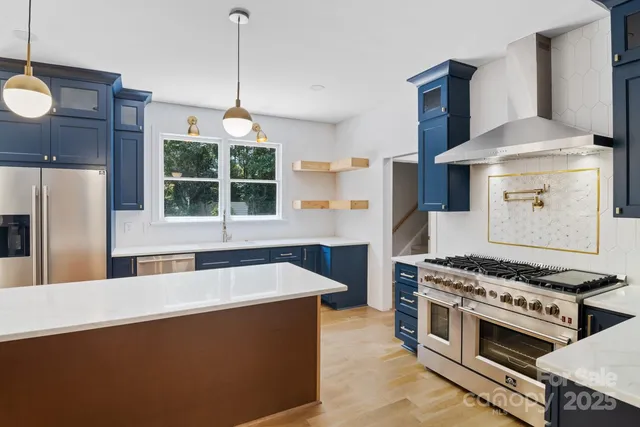 a kitchen with stainless steel appliances granite countertop a stove a refrigerator and a granite counter tops