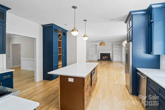 a living room with stainless steel appliances granite countertop furniture and a fireplace