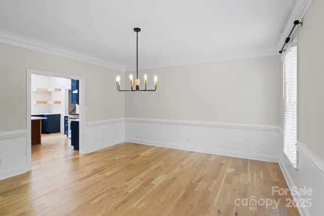 a view of a room with wooden floor staircase and a chandelier