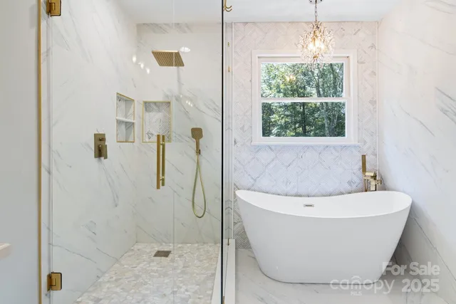 a white bath tub sitting in a bathroom next to a window