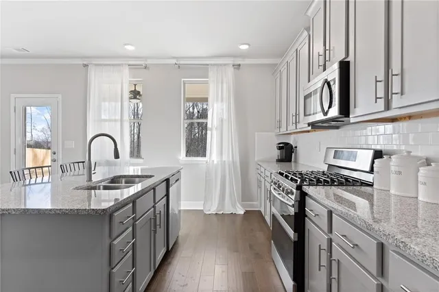 a kitchen with stainless steel appliances granite countertop a stove and a sink