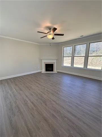 an empty room with windows chandelier fan and windows