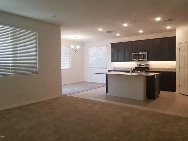 a view of a kitchen with a sink wooden cabinets and window