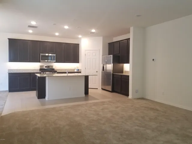 a kitchen with stainless steel appliances granite countertop a refrigerator and a stove