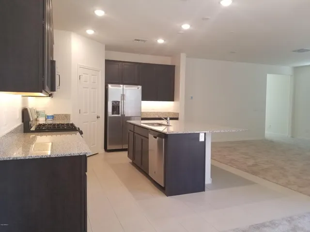 a kitchen with stainless steel appliances granite countertop a sink and a stove