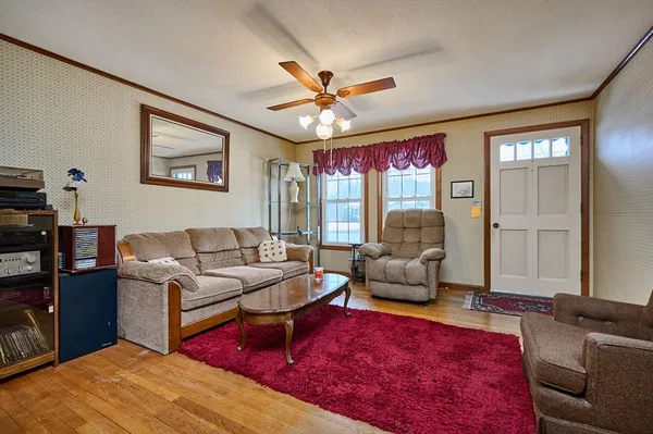a living room with furniture ceiling fan and a rug