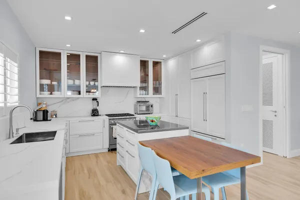 a kitchen with stainless steel appliances wooden floor dining table and chairs