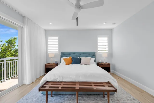 a bed sitting in a spacious bedroom next to a window