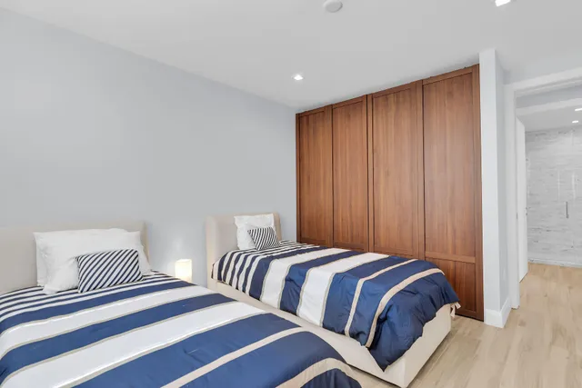 a bedroom with two beds and a wooden floor