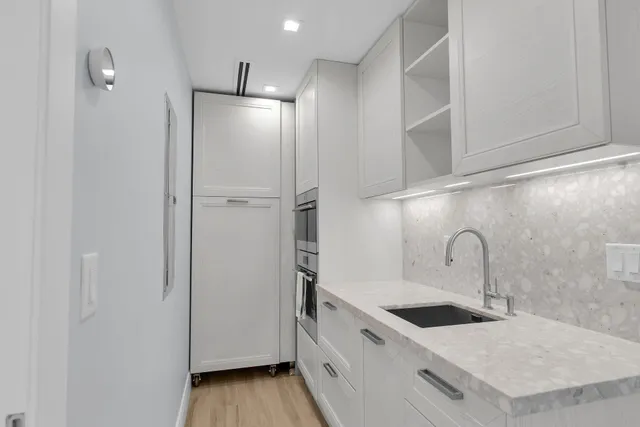 a kitchen with stainless steel appliances granite countertop a sink and a refrigerator