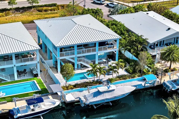 an aerial view of a residential houses with outdoor space and trees