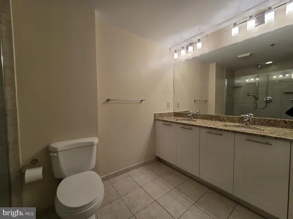 a bathroom with a granite countertop toilet and a sink