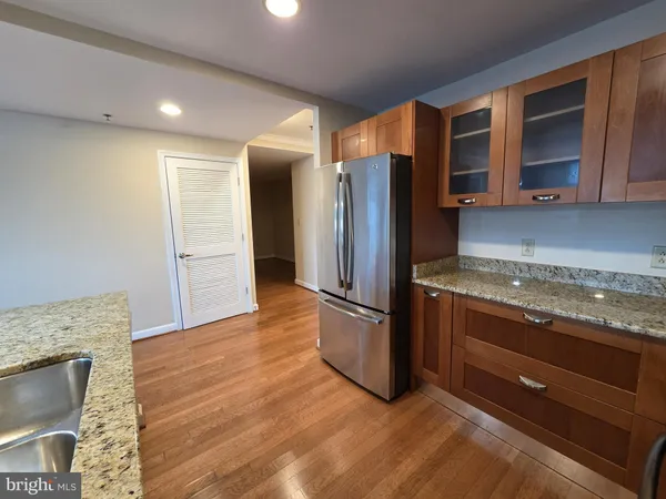 a kitchen with stainless steel appliances granite countertop a refrigerator and a stove top oven