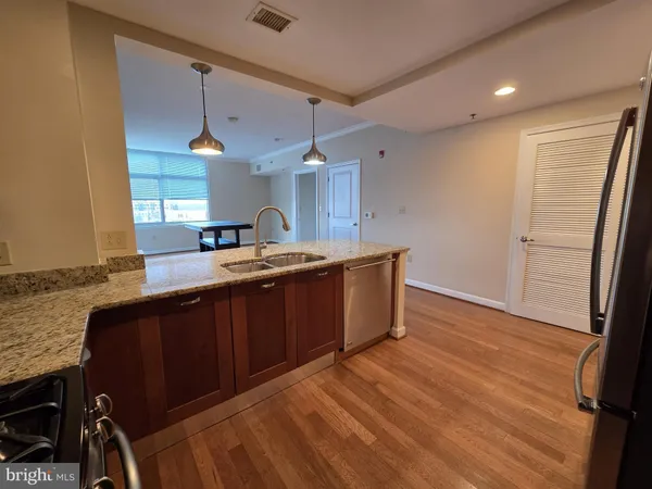 a kitchen with a sink a counter space appliances and cabinets