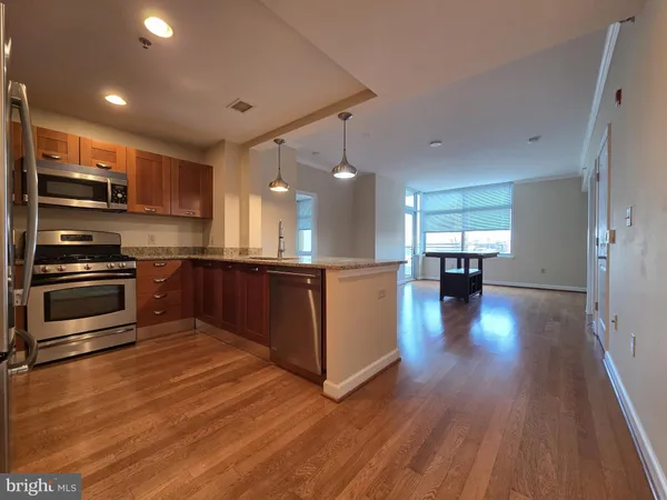 a kitchen with kitchen island wooden floors and appliances