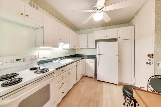 a kitchen with granite countertop cabinets and white appliances