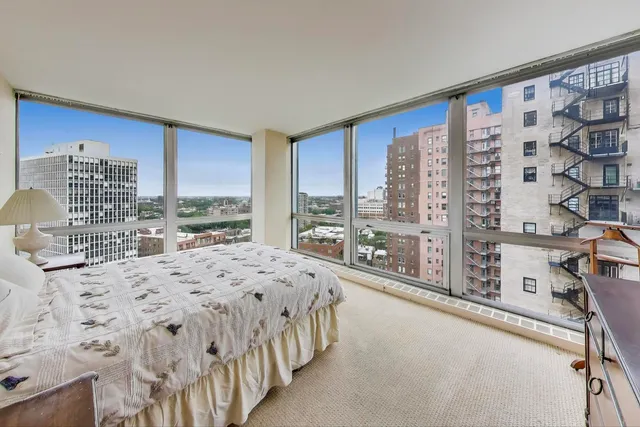 a spacious bedroom with a bed lamp and a large window