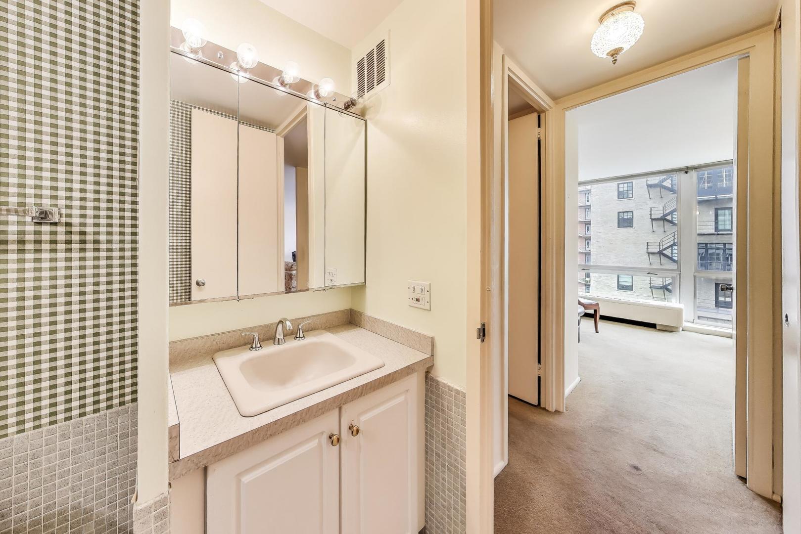 2400 North Lakeview Avenue, Unit 1708 Chicago, IL 60614 - Photo 28 of 50 a bathroom with a sink a mirror and a shower
