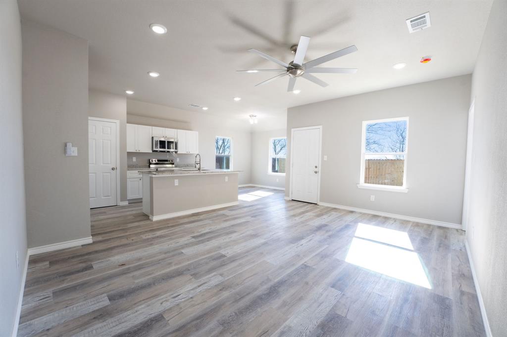 1032 Springview Lane Mabank, TX 75147 - Photo 3 of 15 Unfurnished living room featuring a ceiling fan, light wood-style flooring, and recessed lighting
