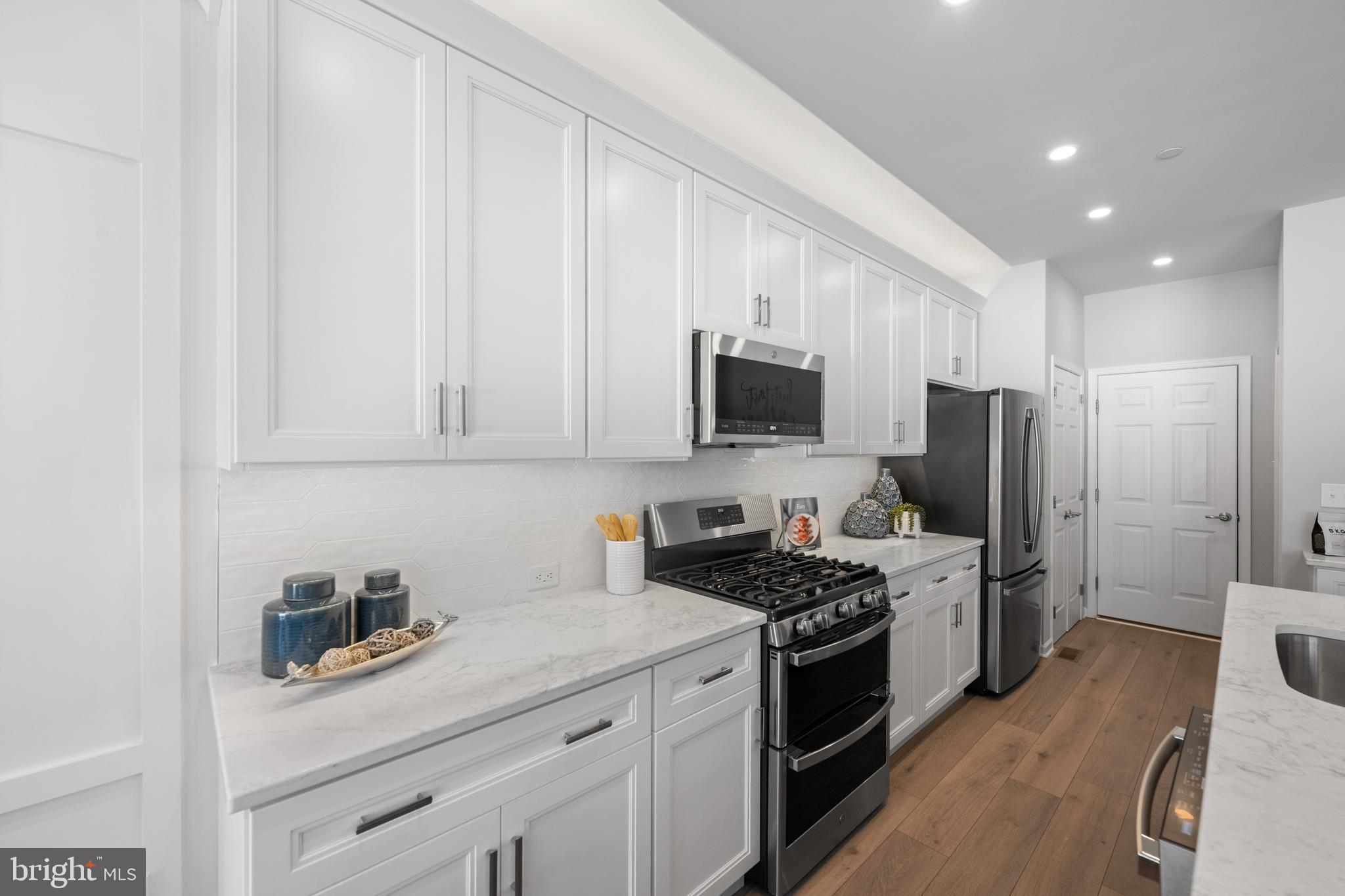 156 Bancroft Road, Unit CARLTON Kennett Square, PA 19348 - Photo 8 of 47 a kitchen with stainless steel appliances white cabinets and a stove top oven