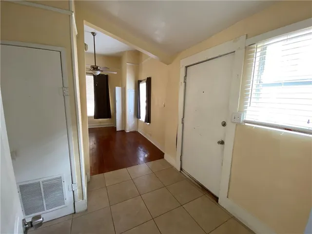 a view of a hallway with wooden floor and cabinet