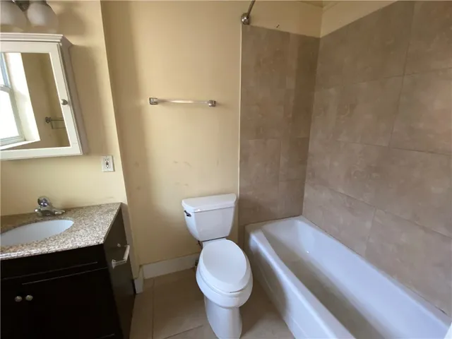 a bathroom with a granite countertop toilet and a sink